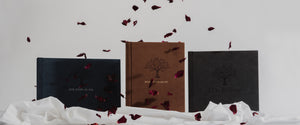 Three bible photo albums with rose petals and white cloth.